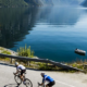 Image of a group of cyclists cycling along a beautiful fjord while on the norway atlantic coast ride high up in the arctic circle