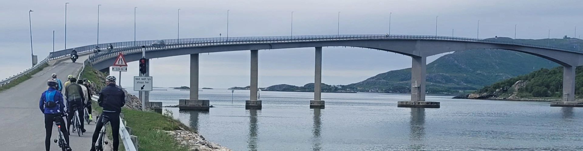 cyclists in Norway waiting to cross one of the many spectacular bridges to an island while on the Norway Atlantic coast ride high up in the Arctic circle