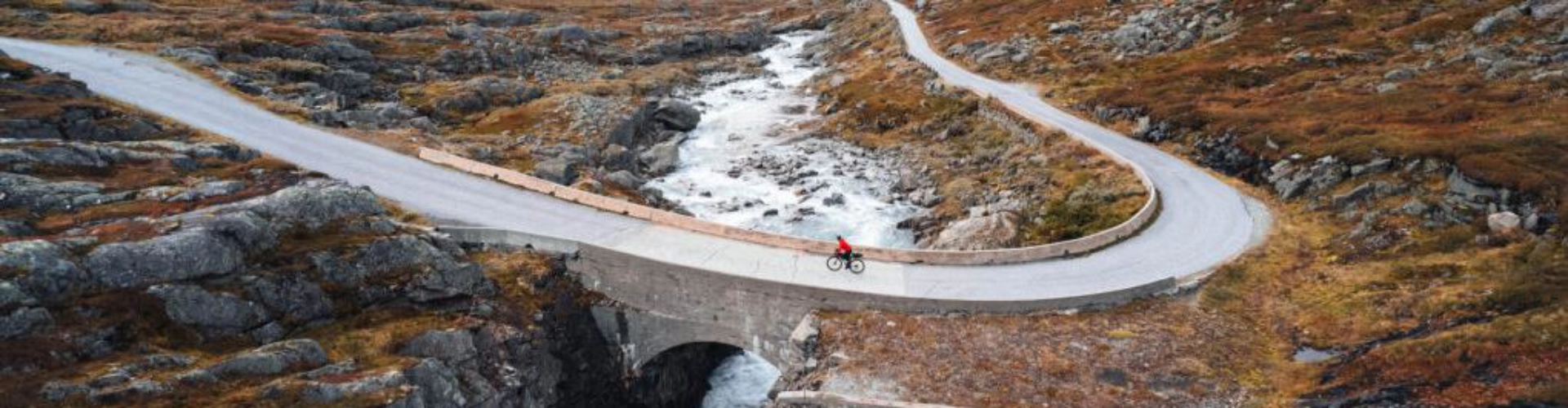 cyclist riding his bike in Norway on one of the peaceful roads while on the Norway Atlantic coast ride cycling holiday high up in the Arctic circle