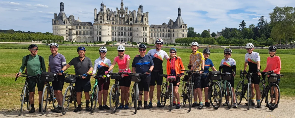 Cyclists admiring the renaissance architecture of château de chambord during an organized france bike tour