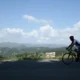 A panoramic view of a cyclist on a scenic winding road with a transylvanian mountain backdrop explore our detailed guide to planning a professional cycling holiday in romania