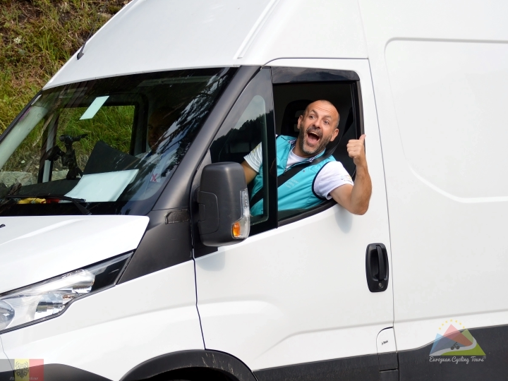 Professional support vehicle driver providing assistance on a guided cycling trip; explore the benefits of a fully supported tour.