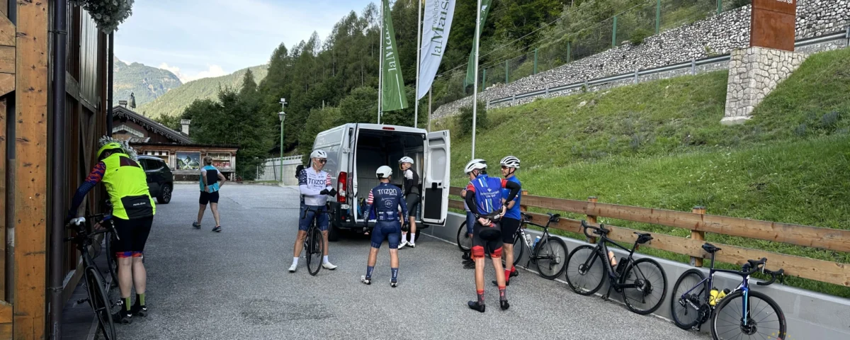 Cyclists gathering around a professional european cycling tours support van for refreshments and mechanical assistance