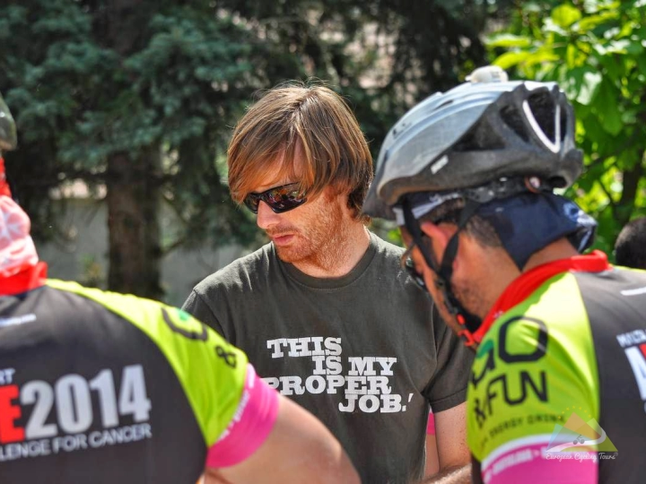 European Cycling Tours support team assisting riders with bike maintenance and supplies on a mountain pass; learn more about the benefits of guided cycling.