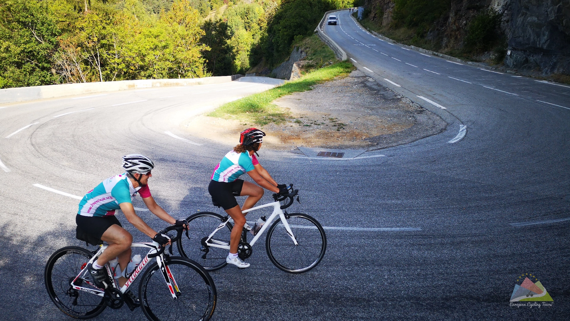 A group of road cyclists navigating the famous alpe d huez switchbacks in the french alps during a supported mountain climb view our portfolio of legendary european cycling itineraries