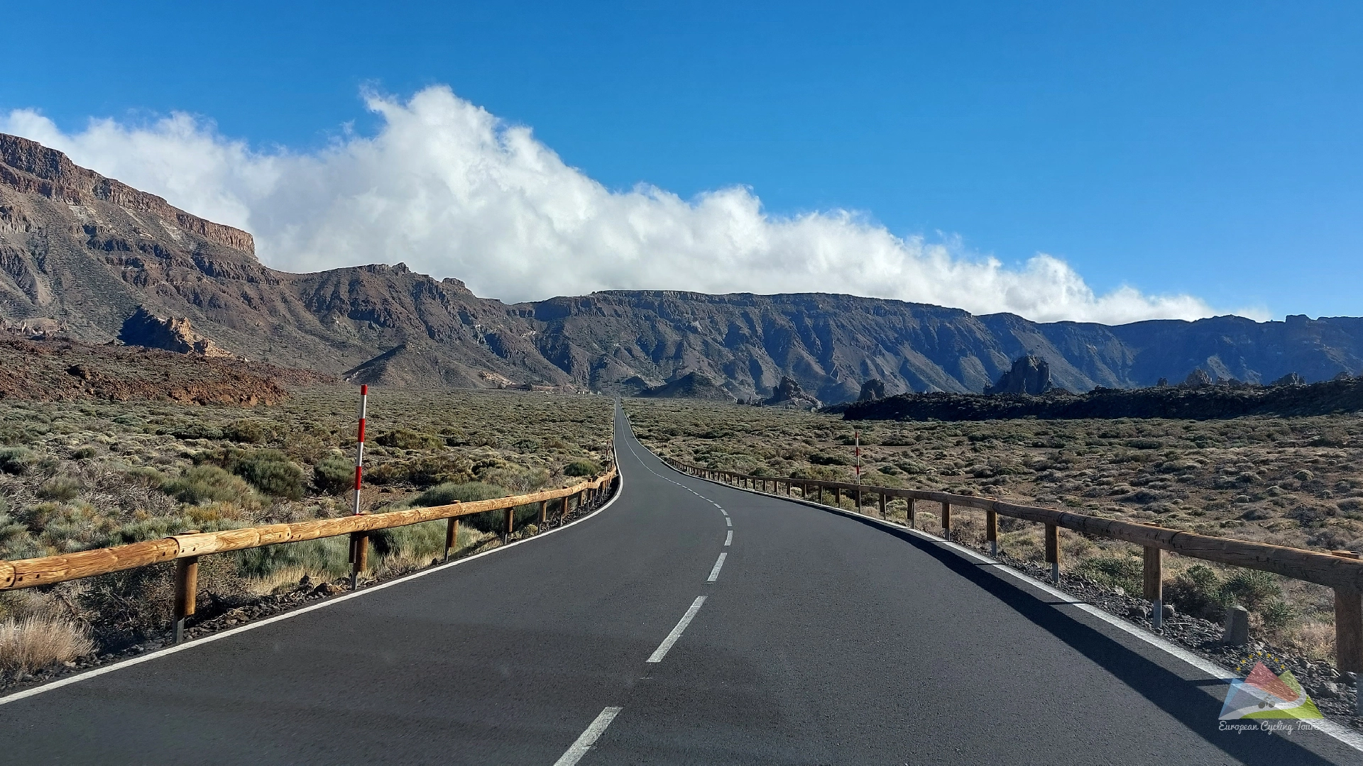 A cyclists view looking down the road toward the mount teide lava fields during a guided road cycling holiday explore our comprehensive range of supported european mountain tours