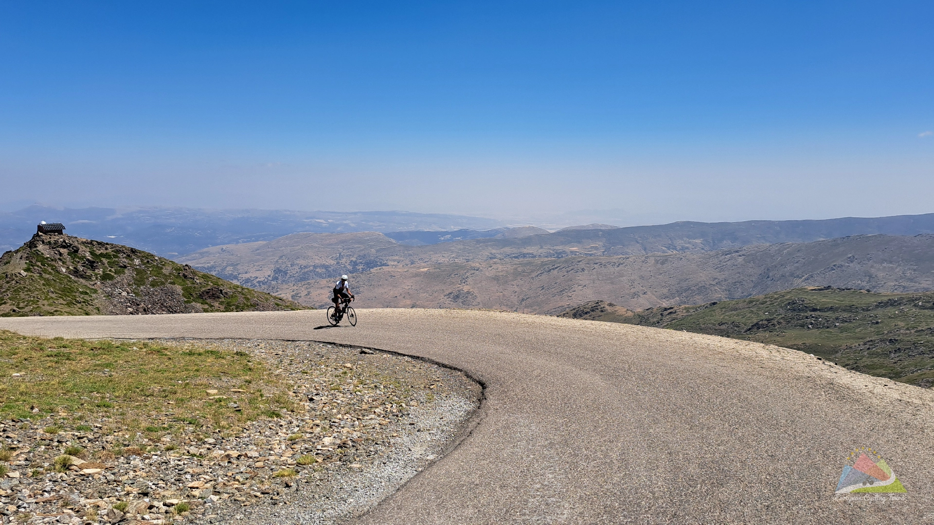 A cyclist enjoying the final ascent to the pico de veleta summit in the sierra nevada mountains explore our portfolio of guided tours to the highest climbs in europe