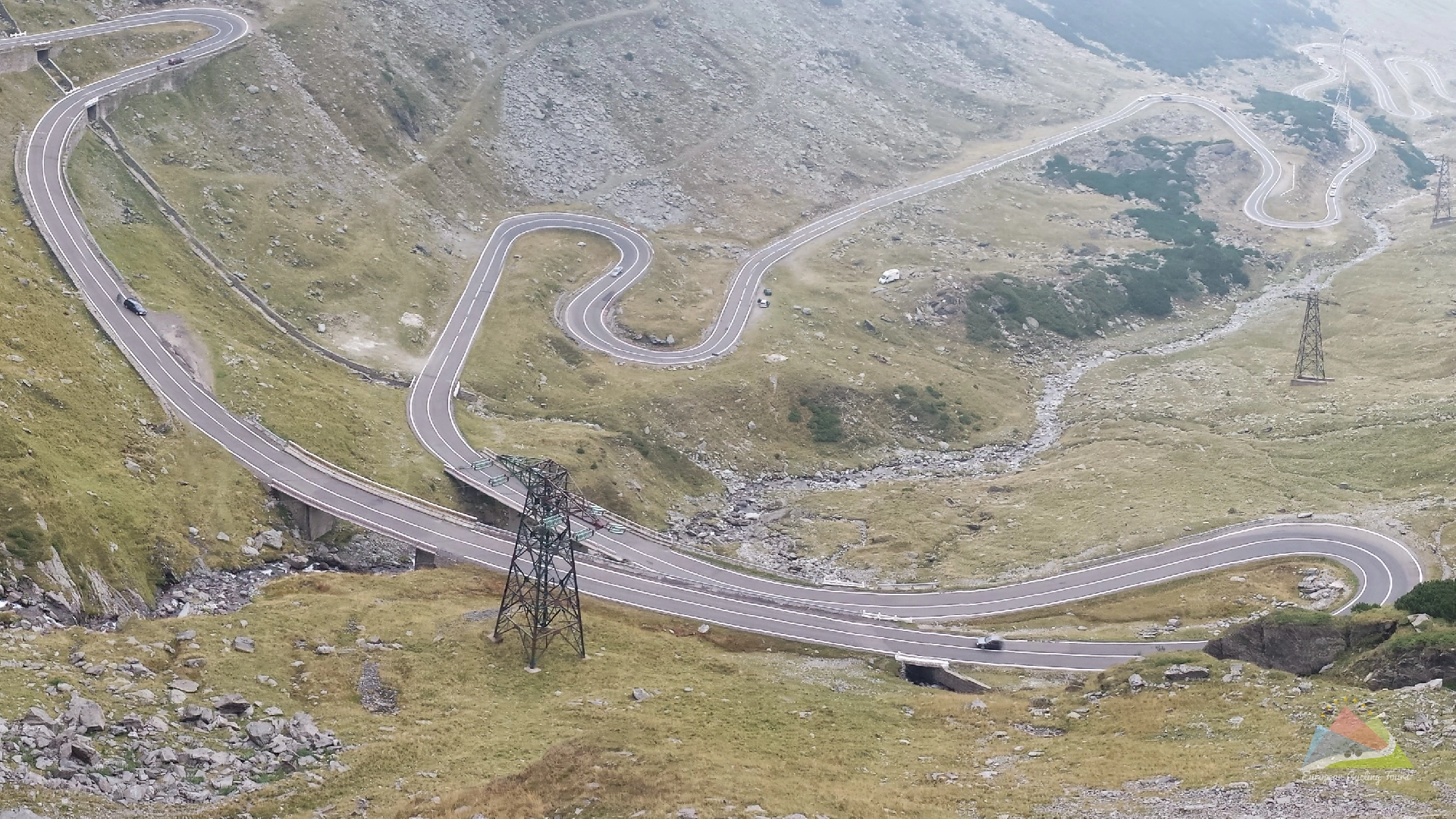 A group of cyclists enjoying a high speed descent on the transfagarasan pass road in romania discover our professionally guided itineraries for the most iconic mountain climbs in europe