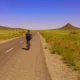 The erg chebbi approach in the drâa tafilalet region featuring vast desert plains for guided road cycling providing adventurous serenity for a cyclist riding toward the dunes explore our morocco itineraries